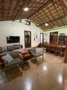 a living room with a couch and tables and chairs at Sítio Funilândia - MG in Funilândia