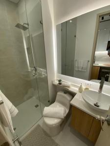 a bathroom with a shower and a toilet and a sink at Apartasuite Cowork in Bogotá +9 photos