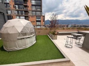 a gazebo on the roof of a building with green grass at Apartasuite Cowork in Bogotá