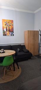 a living room with a black couch and a table at Górnośląska 19 in Zawiercie