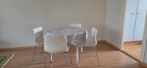 a dining room table with white chairs and a table cloth at Pankkikallio 14 in Sorsakoski