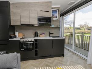 a kitchen with a stove top oven next to a balcony at Dawn's Rest in Rhayader