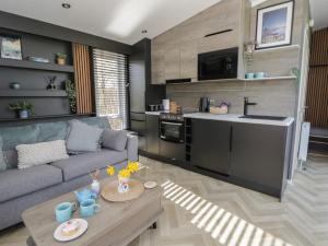 a living room with a couch and a kitchen at Dawn's Rest in Rhayader