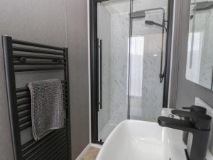 a bathroom with a sink and a glass shower at Dawn's Rest in Rhayader +9 photos
