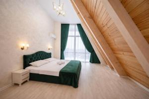a bedroom with a green bed and a large window at ES Dream A-Frame Cabin in Gabala