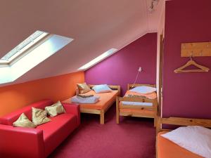 a attic room with two beds and a couch at Beachside Guest House Strautini in Plieņciems