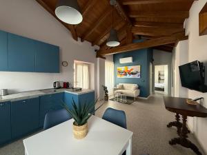 a kitchen with blue cabinets and a table and chairs at La Corte dei Mercanti by Stresahome - Centro Storico in Stresa