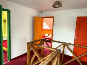 a room with two orange doors and a mirror at Beachside Guest House Strautini in Plieņciems