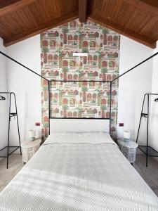 a white bed in a room with a brick wall at La Corte dei Mercanti by Stresahome - Centro Storico in Stresa