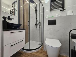 a bathroom with a glass shower and a toilet at Ośrodek Uzdrowiskowy Biawena in Wysowa-Zdrój