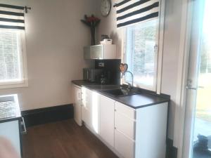 a kitchen with a sink and a microwave at Pihapiilo in Raahe +14 photos
