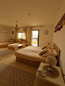a bedroom with two beds and a living room at B&B petrafarmhouse in Wadi Musa
