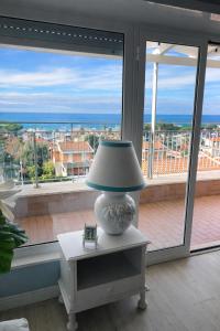 a lamp sitting on a table in front of a window at Due Passi dal Cielo Apartment Piscina Condominiale fino al 30 Agosto in Anzio