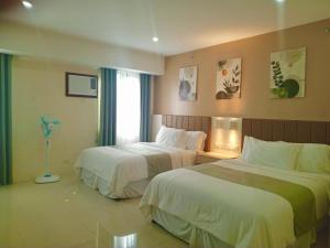 a hotel room with two beds and a window at Baba Staytion 1-2-3 of SMDC Style Condo in Iloilo City