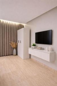 a living room with a television and a white cabinet at Modern Studio Near Al Haram And City Center Self Check-in in Medina
