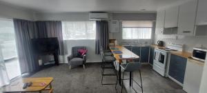 a kitchen with blue cabinets and a table and chairs at Fantastic Two Bedroom Unit in Whakatane