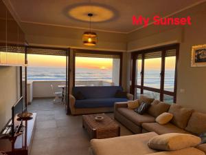 a living room with a couch and a view of the ocean at My Sunset in Torvaianica
