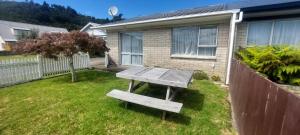 a picnic table in a yard in front of a house at Fantastic Two Bedroom Unit in Whakatane