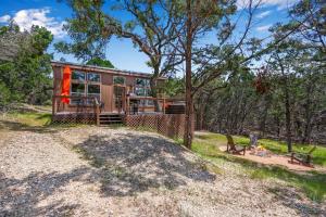 a cabin in the woods with a dog sitting in front of it at Martha at the Bend in Wimberley +14 photos