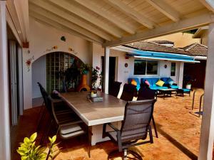 a patio with a table and chairs and a couch at A Newly Renovated Luxury 4 Bed Villa in Tortola Island