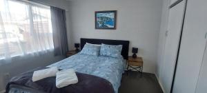 a bedroom with a bed with blue sheets and pillows at Fantastic Two Bedroom Unit in Whakatane