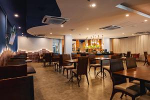 a restaurant with tables and chairs and a bar at Ibis Styles Macaé in Macaé