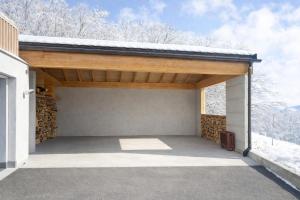 a garage with a roof with snow on it at Maison D'Hortense chalet le Chamois in Hérémence +10 photos