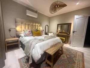 a bedroom with a large bed with a bench on it at 20 At Jeanette in Windhoek
