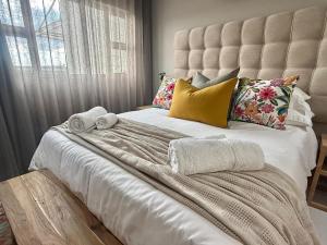 a bedroom with a large white bed with towels on it at 20 At Jeanette in Windhoek +17 photos