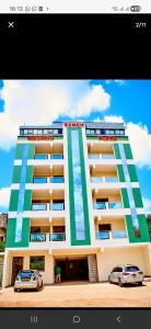 a building with two cars parked in front of it at PAZURI - Homes in Voi
