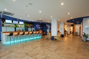 a bar in a hotel with chairs and tables at Ibis Styles Macaé in Macaé
