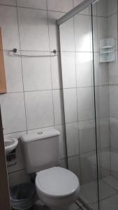a bathroom with a toilet and a glass shower at Golden Hotel Ltda - Próximo a DPM, Aeroporto, Rodoviaria Porto Alegre, Arena do Grêmio in Porto Alegre