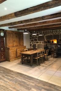 a dining room with a table and a stone wall at Gite de collandres in Cheylade