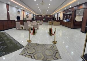 a lobby with tables and chairs in a building at ثار بارك للشقق المخدومة in Qushayya