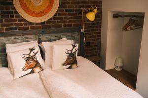 a bed with two deer heads on the pillows at Vakantiehuis ABEL in Dilsen-Stokkem