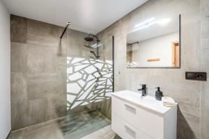 a bathroom with a sink and a shower with a mirror at Studio Arnoštka in Vimperk