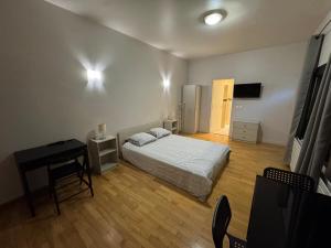 a bedroom with a bed and a desk and a television at Private Spa & Zen Atmosphere in Coubron