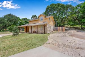 a brick house with a driveway in front of it at Mi Rancho in Wimberley