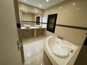 a large bathroom with a tub and two sinks at Private Spa & Zen Atmosphere in Coubron +10 photos