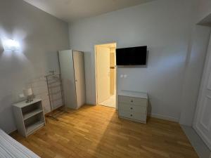 an empty room with a bed and a television on a wall at Private Spa & Zen Atmosphere in Coubron