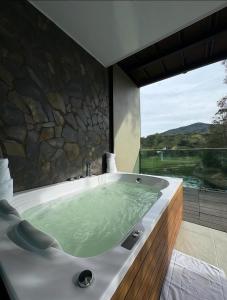 a bath tub in a bathroom with a large window at Hotel Nova El Peñol in El Peñol
