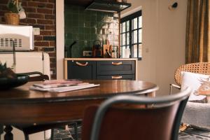 a kitchen with a wooden table with chairs and a counter at Vakantiehuis ABEL in Dilsen-Stokkem