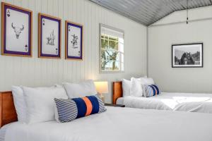 two beds in a room with pictures on the wall at Daybreak Ridge Entire Property in Blanco