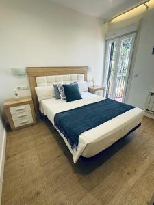 a bedroom with a large bed with a blue blanket at Villa puerto marina beach in Benalmádena