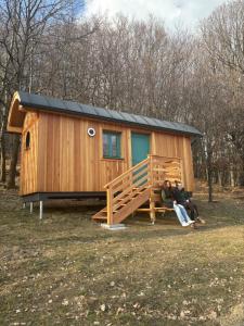two people sitting in front of a tiny house at Sad u Harušťákov in Lubina