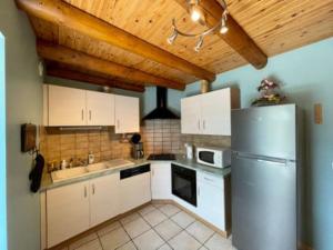 a kitchen with white cabinets and a stainless steel refrigerator at gite La Fermette in Valprivas
