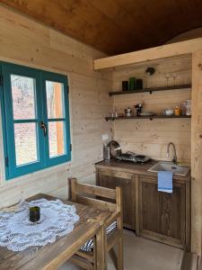 a kitchen with a table and a window in a cabin at Sad u Harušťákov in Lubina