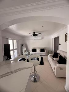 a white living room with a couch and a table at Villa Ray in Gros Islet