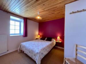 a bedroom with a bed and a wooden ceiling at gite La Fermette in Valprivas