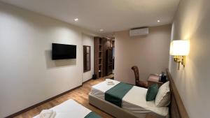 a hotel room with two beds and a flat screen tv at Shams Boutique Hotel in Bukhara